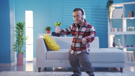 Cheerful-disabled-dwarf-young-man-dancing-while-listening-to-music-with-headphones.